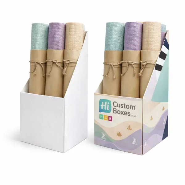 Two cardboard display stands holding rolled yoga mats wrapped in brown paper with rustic twine bows- class=